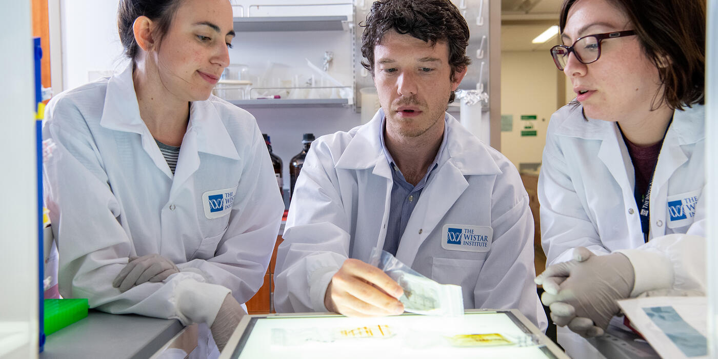 Dr. Alessandro Gardini, flanked by two lab members